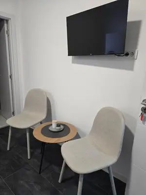 two chairs and a table with a tv on a wall at Stari Vuk in Belgrade