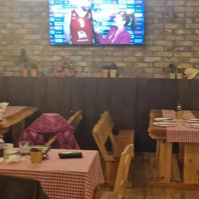 a dining room with tables and a tv on the wall at Stari Vuk in Belgrade