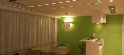 a kitchen with green walls and a table and a light at Perfect place to stay in Belgrade