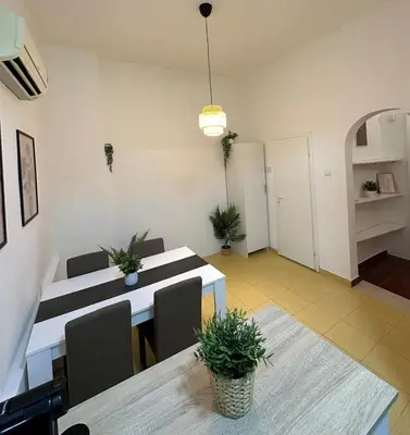 a dining room with a table and chairs in a room at Skadarlija Retro Charming Apartment in Belgrade