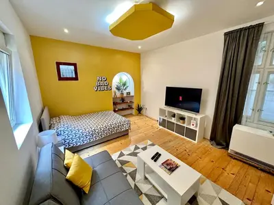 a living room with a couch and a tv at Skadarlija Retro Charming Apartment in Belgrade