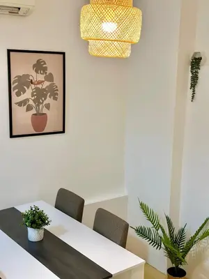 a dining room table with chairs and a potted plant at Skadarlija Retro Charming Apartment in Belgrade
