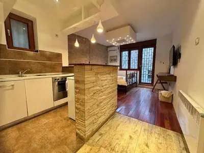 a kitchen with a stone wall in the middle at Studio Skadarlija in Belgrade