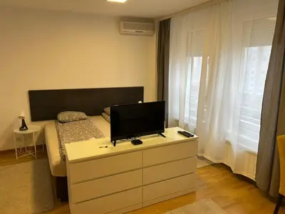 a bedroom with a bed with a tv on a dresser at Apartment Premier 3 Belville in Belgrade