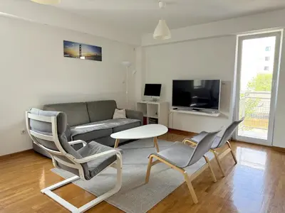 a living room with a couch and chairs and a table at Lovely modern 1-bedroom with balcony in Obrenovac