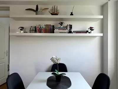 a dining room with a white table with two chairs at Lovely modern 1-bedroom with balcony in Obrenovac