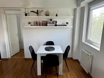 a white table and chairs in a room at Lovely modern 1-bedroom with balcony in Obrenovac