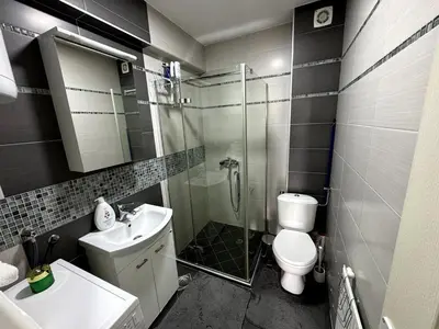 a bathroom with a shower and a toilet and a sink at Lovely modern 1-bedroom with balcony in Obrenovac