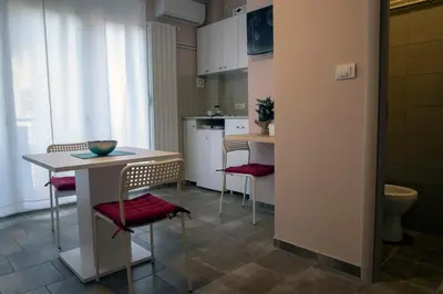 a kitchen with a table and chairs and a kitchen with a sink at Studio Anrora 3 in Belgrade