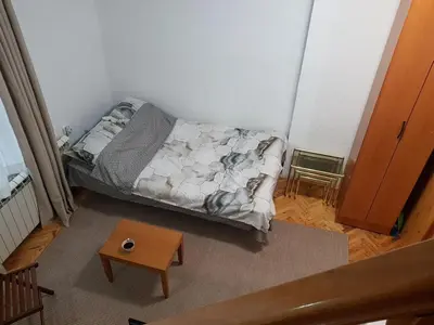 a small bedroom with a bed and a table at Ozon in Belgrade