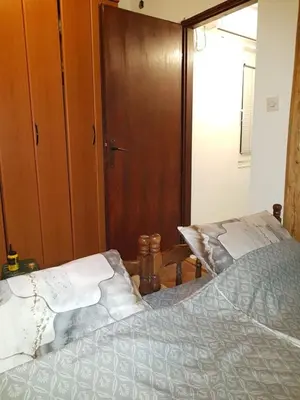 a bedroom with a bed and a wooden door at Ozon in Belgrade
