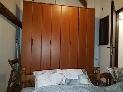 a bedroom with a large wooden cabinet next to a bed at Ozon in Belgrade