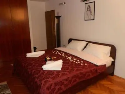 a bedroom with a bed with a red blanket and white pillows at Hostel Mondeo in Belgrade