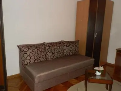 a couch in a living room with a table at Hostel Mondeo in Belgrade
