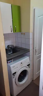 a kitchen with a washing machine and a sink at Apartman Mikica in Pančevo