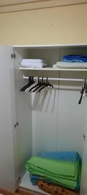 a white closet with a green towel on a shelf at Apartman Mikica in Pančevo
