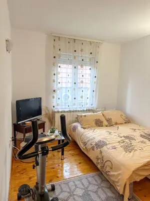 a bedroom with a bed and a desk with a computer at Orhideja in Belgrade