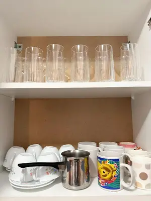 a shelf filled with glasses and cups and dishes at Orhideja in Belgrade