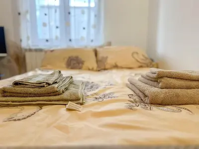 a bed with a pile of towels on it at Orhideja in Belgrade