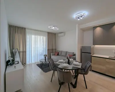 a kitchen and a living room with a table and chairs at Waterfront Belgrade Peaceful Nest Apartment in Belgrade