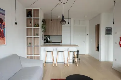 a kitchen and living room with a counter and stools at HostGost Selected Suites - K District in Belgrade