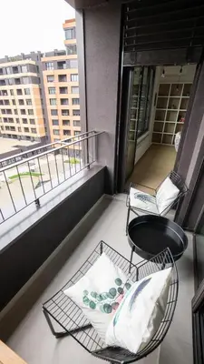 a balcony with a table and chairs on a building at HostGost Selected Suites - K District in Belgrade
