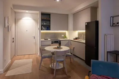 a kitchen with a table and chairs and a refrigerator at Belgrade Waterfront Lux in Belgrade