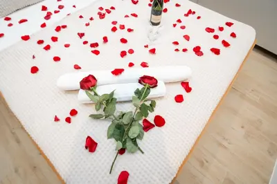 a table topped with red roses and a bottle of champagne at Boho House Skadarlija in Belgrade