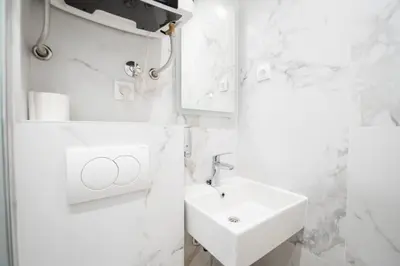 a white bathroom with a sink and a mirror at Boho House Skadarlija in Belgrade