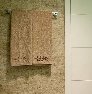 two towels hanging on a wall in a bathroom at Brilijant Lux Apartman in Arandjelovac