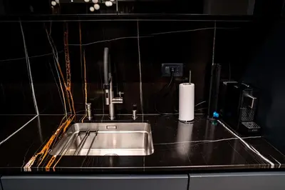 a kitchen counter with a sink and a paper towel at Brilijant Lux Apartman in Arandjelovac