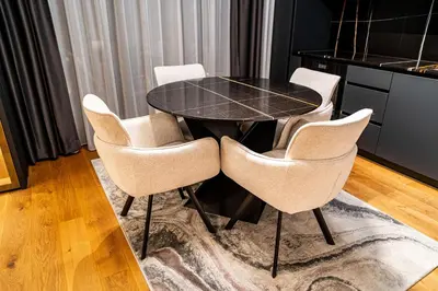 a dining room with a black table and chairs at Brilijant Lux Apartman in Arandjelovac