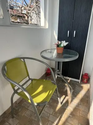 a green chair and a table with a plant on it at City Vibe in Belgrade