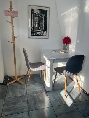 a white table with two chairs and a table with flowers at City Vibe in Belgrade