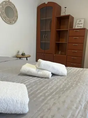 a bedroom with two towels on a bed with a dresser at City Vibe in Belgrade