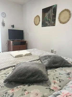a bedroom with two beds with pillows and a television at City Vibe in Belgrade
