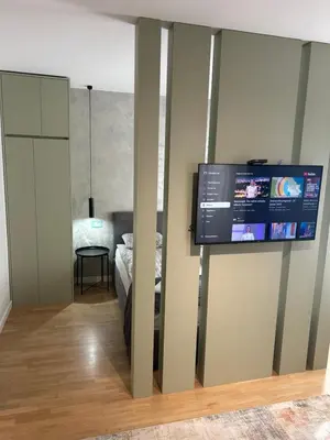 a room with a tv on a wall with a bed at Belvil 5 in Belgrade