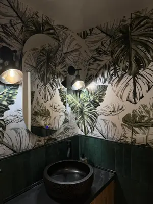 a bathroom with a sink and plants on the wall at Romero Velvet Nights in Belgrade