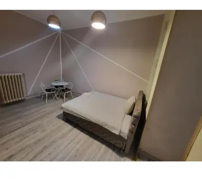 a bedroom with a bed and a table in a room at Fine Plus in Belgrade