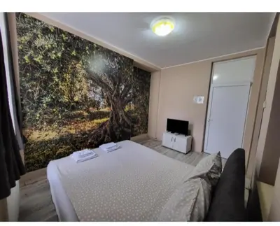 a bedroom with a bed with a painting on the wall at Fine Plus in Belgrade