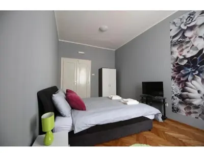 a bedroom with a bed and a painting on the wall at Fine Plus in Belgrade