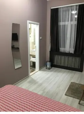 a bedroom with a bed and a mirror and a door at Fine Plus in Belgrade