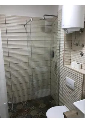 a shower with a glass door in a bathroom at Fine Plus in Belgrade