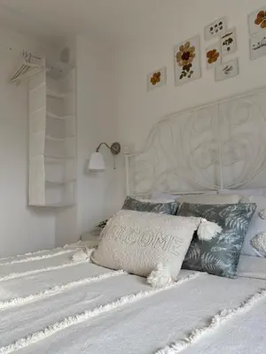 a bedroom with a white bed with a white headboard at Vikendica Fruška lipa in Čortanovci