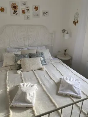 a white bed with two white pillows on it at Vikendica Fruška lipa in Čortanovci