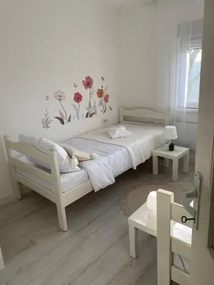 a bedroom with a bed with flowers on the wall at Vikendica Fruška lipa in Čortanovci