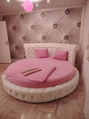a pink bed in a room with a large pink bedvisor at Pinky Belgrade Apartment in Belgrade
