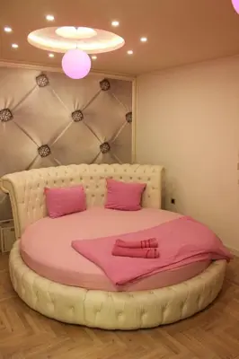 a bedroom with a large bed with pink sheets at Pinky Belgrade Apartment in Belgrade