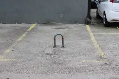 a pole in a parking lot next to a car at Pinky Belgrade Apartment in Belgrade