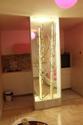 a mirror with trees inside of a room at Pinky Belgrade Apartment in Belgrade